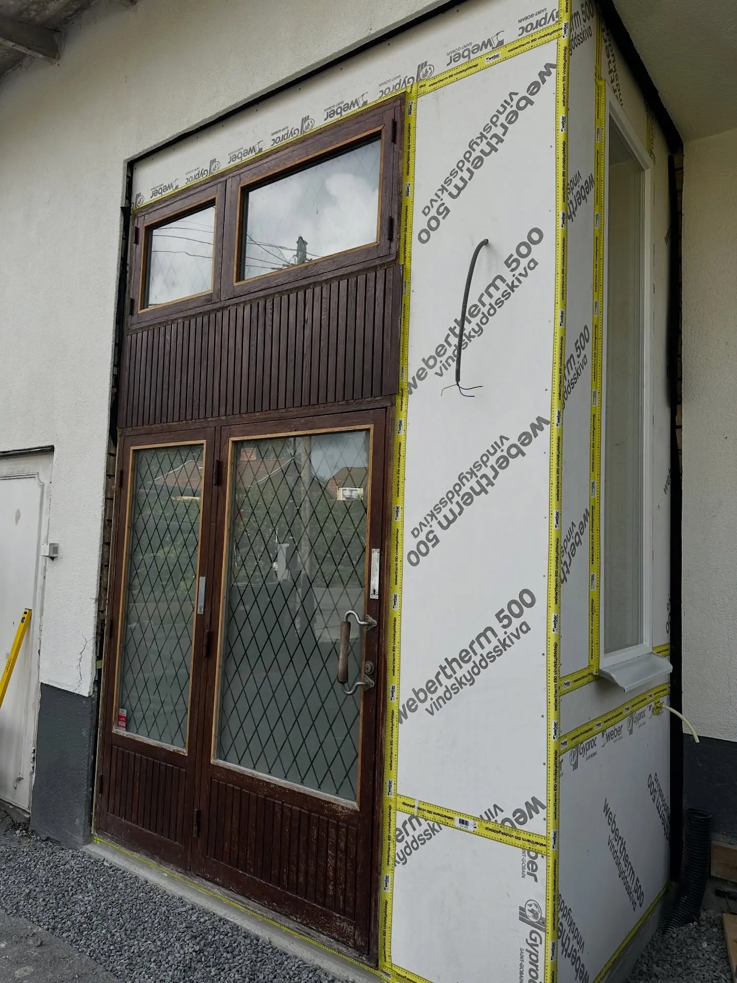 Fasadrenovering runt entrédörr med vindskyddsskiva